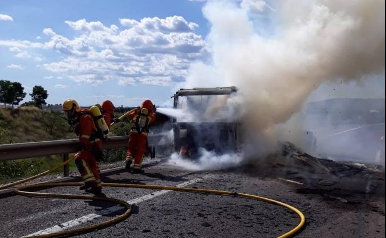 Los bomberos del Consorcio Provincial, apagando el fuego del camión en la A-7.