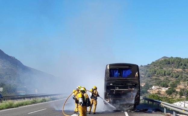 Efectivos de bomberos sofocando el fuego del autobús. 