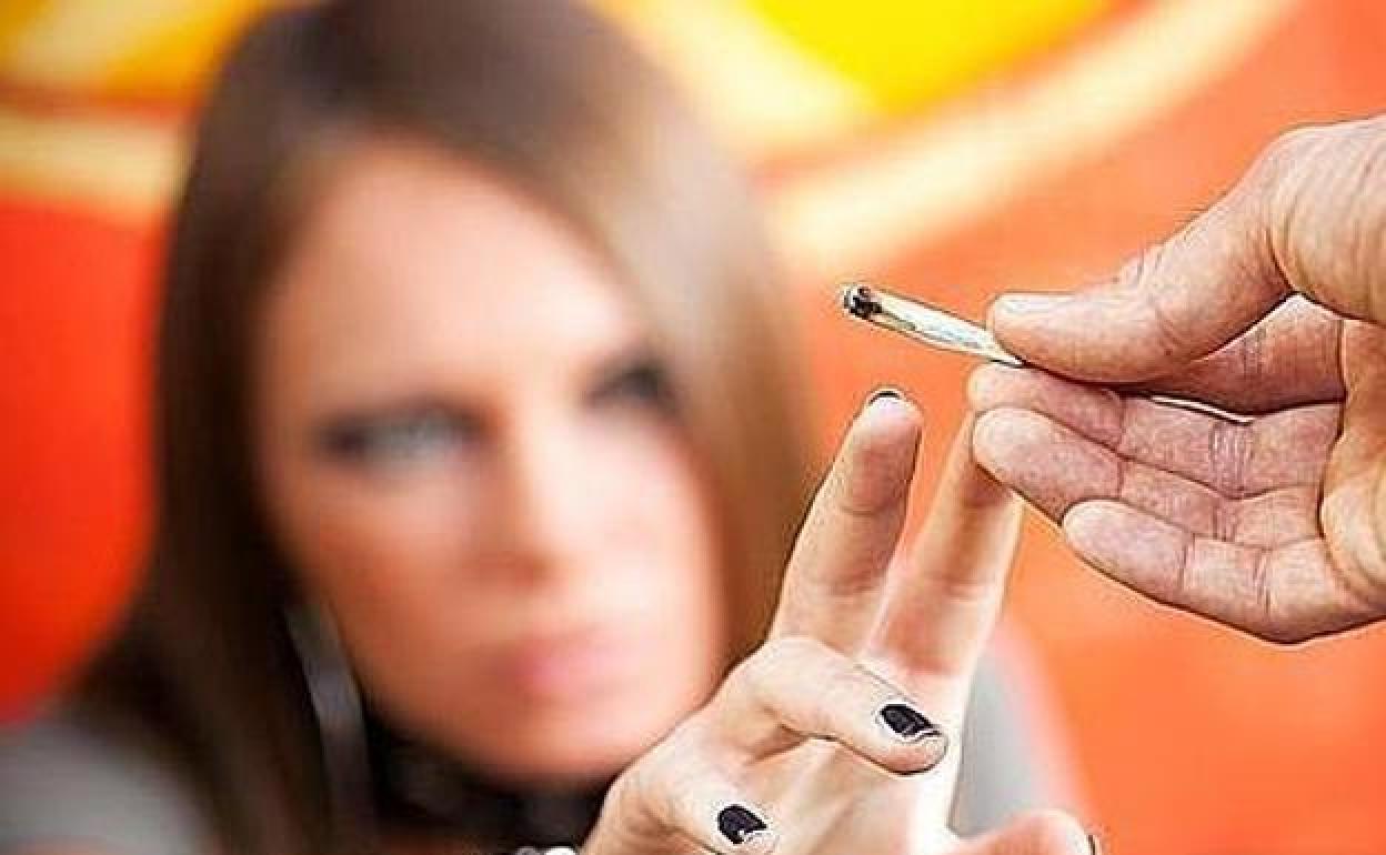 Un hombre ofrece un porro a una joven.