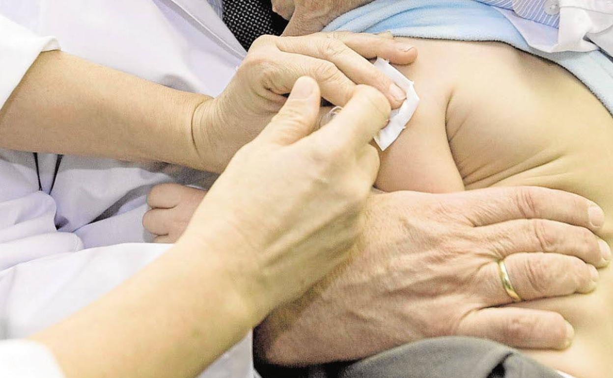 Un niño es vacunado en la consulta de un pediatra. 