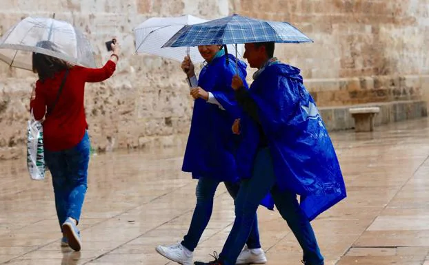 Personas resguardándose de la lluvia en Valencia. 
