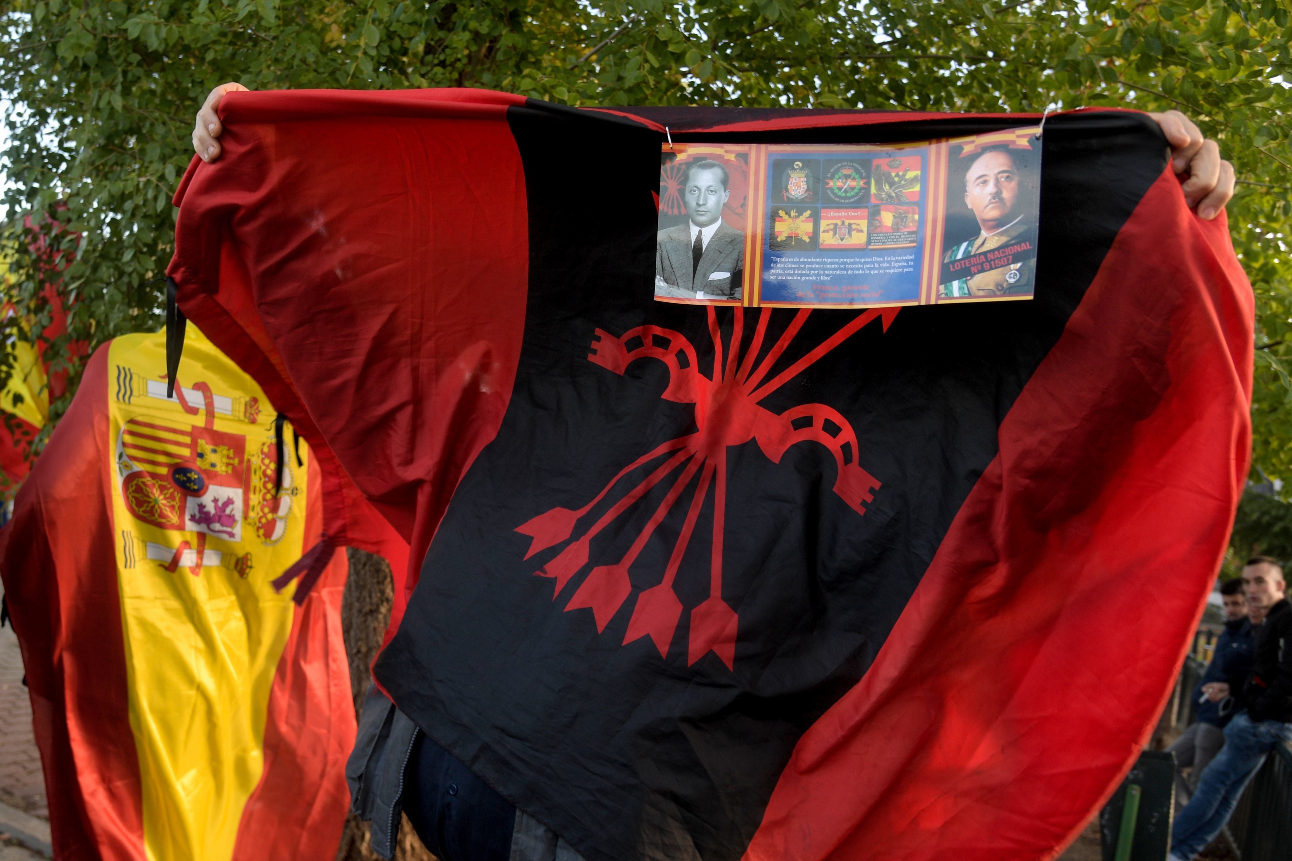 Simpatizantes de Franco se congregan en la entrada del Valle de los Caídos con banderás de España y símbolos franquistas.