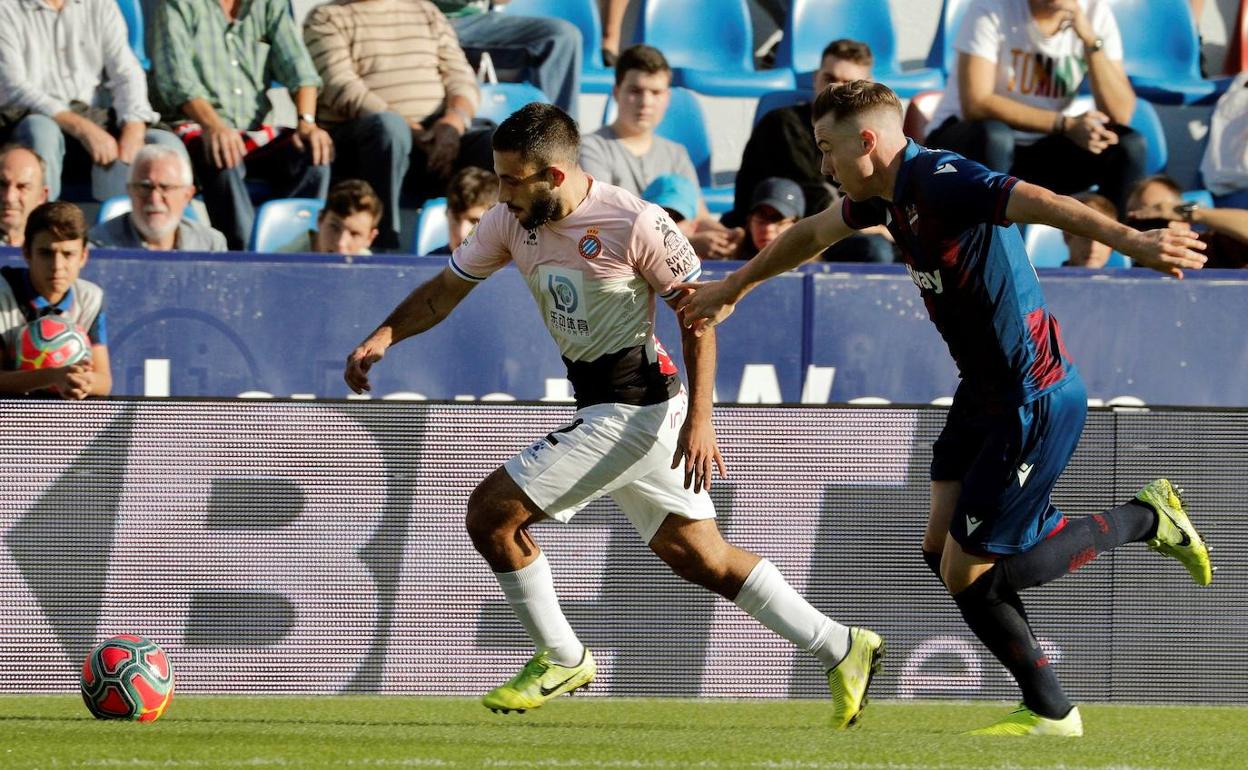 El jugador del Levante Carlos Clerc disputa el balón con el jugador del RCD Espanyol Matías Vargas. 