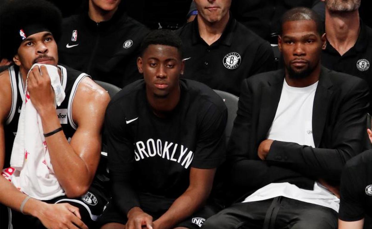 Kevin Durant (d), vestido de calle en el banquillo de los Brooklyn Nets. 