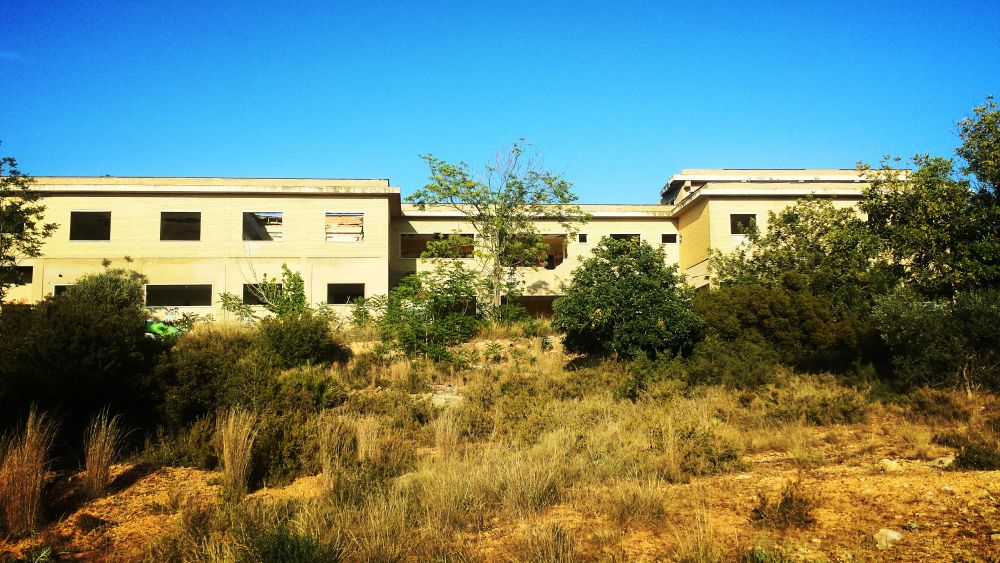 El psiquiátrico infantil abandonado de Cheste (Valencia) | Apenas existen datos concretos sobre su historia, pero sí se sabe que su nombre popular no se corresponde con la realidad de lo que fue. El centro 'La Humanitat' jamás fue un psiquiátrico, sino un centro asistencial para pacientes con distintos grados de deficiencias físicas y psíquicas. Las leyendas que circulan sobre él aseguran que residían aquí niños y enfermos mentales potencialmente peligrosos. La residencia pasó a formar parte en 1986 del Consorcio Valenciano de Servicios Sociales (Convaser) y con el tiempo sus instalaciones dejaron de servir para el modelo asistencial que se pretendía cubrir. El lugar quedó abandonado, objeto de bulos urbanos y objetivo de los adeptos a lo paranormal. La más conocida es la 'leyenda del pasillo quemado' según la cual una enferma o interno prendió fuego al pasillo del ala derecha, ocasionando un incendió en el que -por supuesto- murieron varias personas (según se dice, niños). El lugar, desde luego, da para mucho. Entre muebles, grafitis y pintadas, el pasillo sigue quemado y aún conserva, aunque destrozadas, las bañeras y los aseos que empleaban los residentes. 