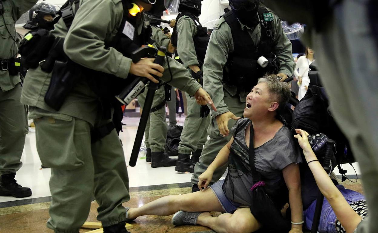 Una manifestante, rodeada por policías en Hong Kong.