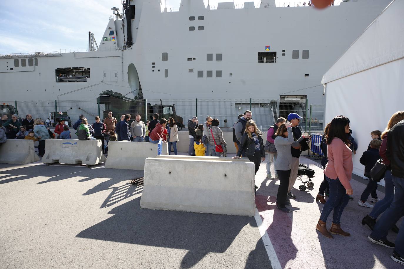 Cientos de personas han hecho largas colas durante la mañana de este sábado para poder subir y descubrir el interior del buque insignia de la Armada, el 'Juan Carlos I'. El portaaviones está atracado durante este fin de semana en el puerto de Valencia y este sábado se celebraba una jornada de puertas abiertas para poder subir y ver cómo es la vida dentro de un barco con más de 200 metros de eslora. 