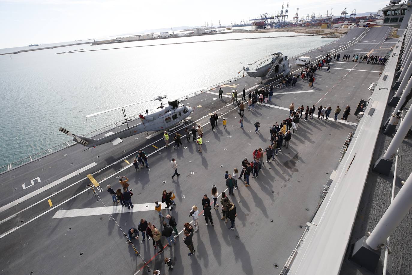 Cientos de personas han hecho largas colas durante la mañana de este sábado para poder subir y descubrir el interior del buque insignia de la Armada, el 'Juan Carlos I'. El portaaviones está atracado durante este fin de semana en el puerto de Valencia y este sábado se celebraba una jornada de puertas abiertas para poder subir y ver cómo es la vida dentro de un barco con más de 200 metros de eslora. 