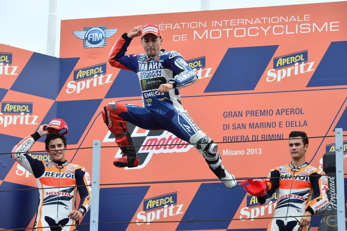 Lorenzo celebra en el podio el triunfo en el Gran Premio de San Marino de Motociclismo, flanqueado por Marc Marquez y Dani Pedrosa, segundo y tercero respectivamente.