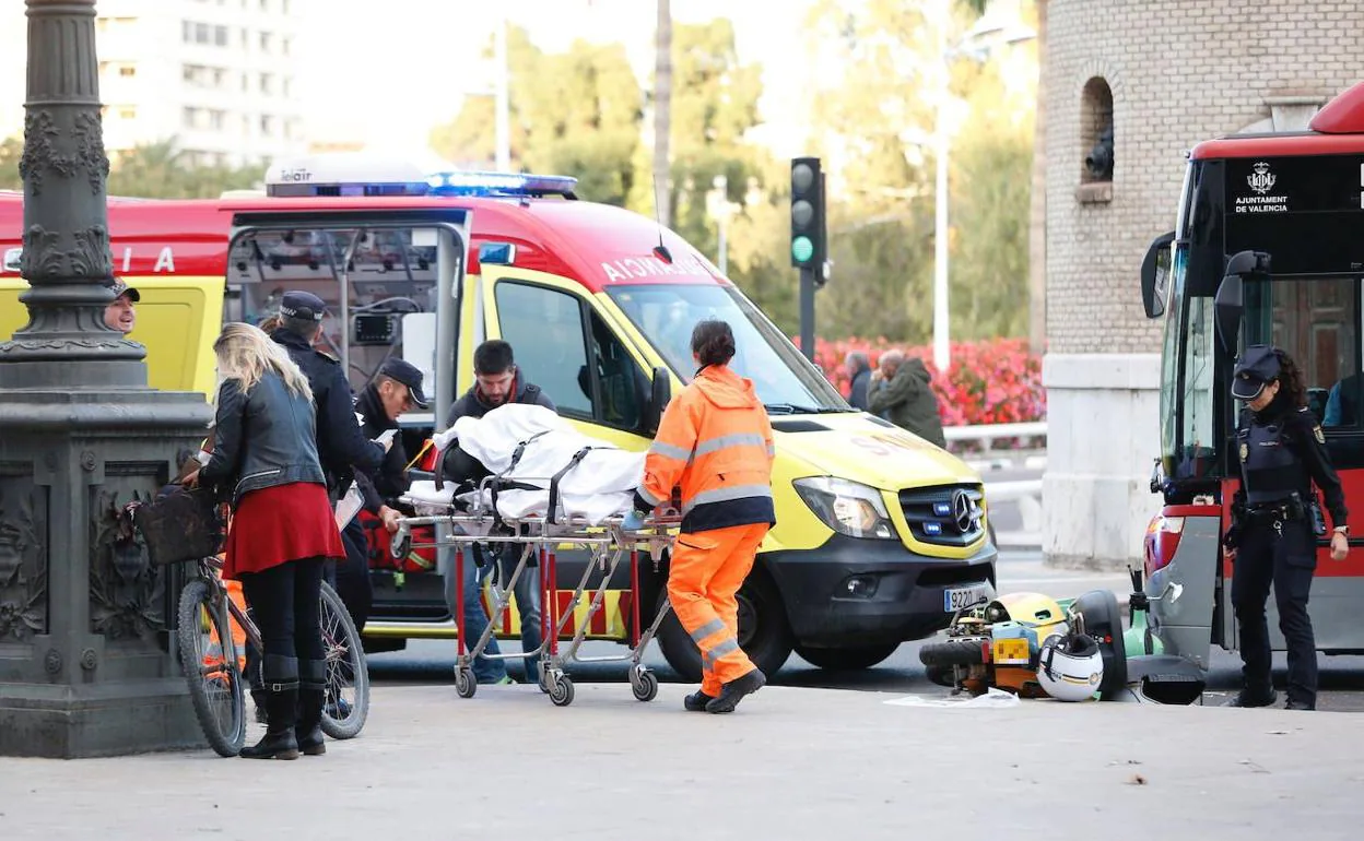 La ambulancia atiende al motorista tras el choque en Valencia.