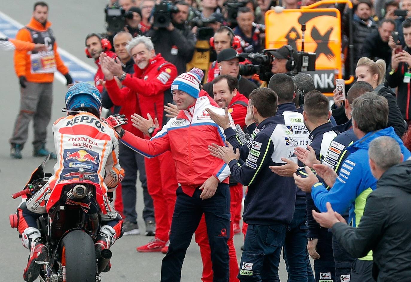 El piloto español de Moto GP, Jorge Lorenzo, se abraza a los miembros de su equipo tras finalizar su última carrera .