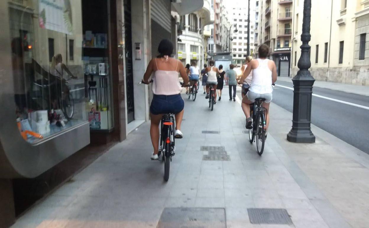 Ciclistas circulan por encima de la acera en Valencia. 