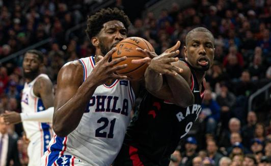 Ibaka disputa un balón con Embiid. 