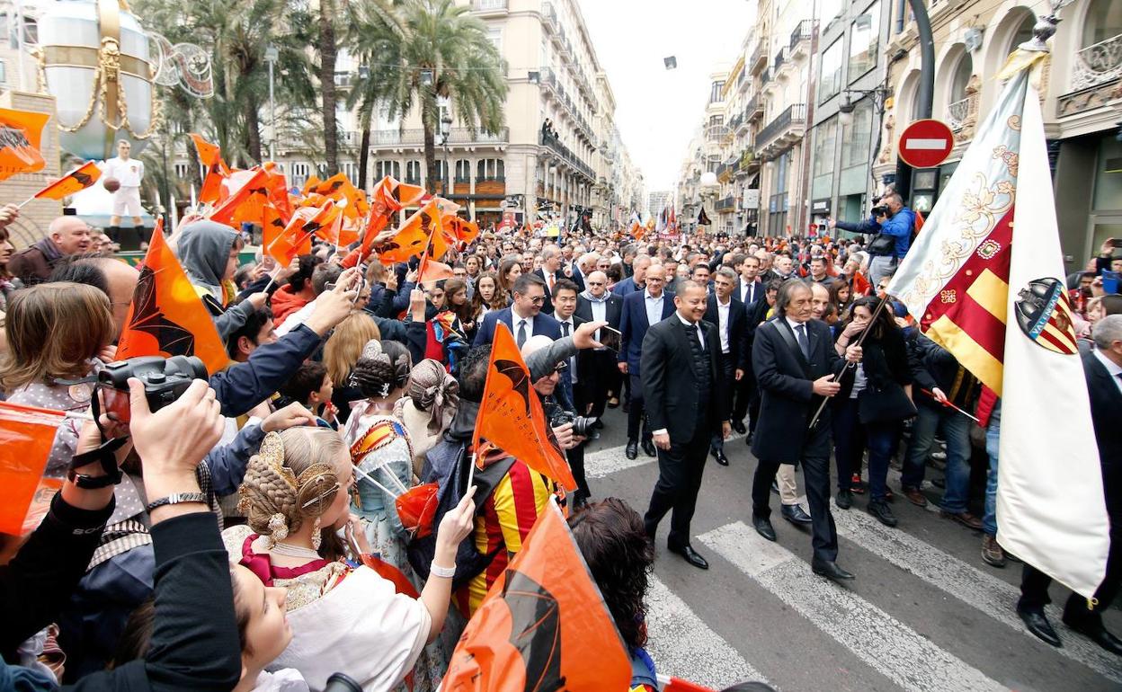 Arias porta la réplica de la bandera fundacional durante la marcha cívica del 18 de marzo