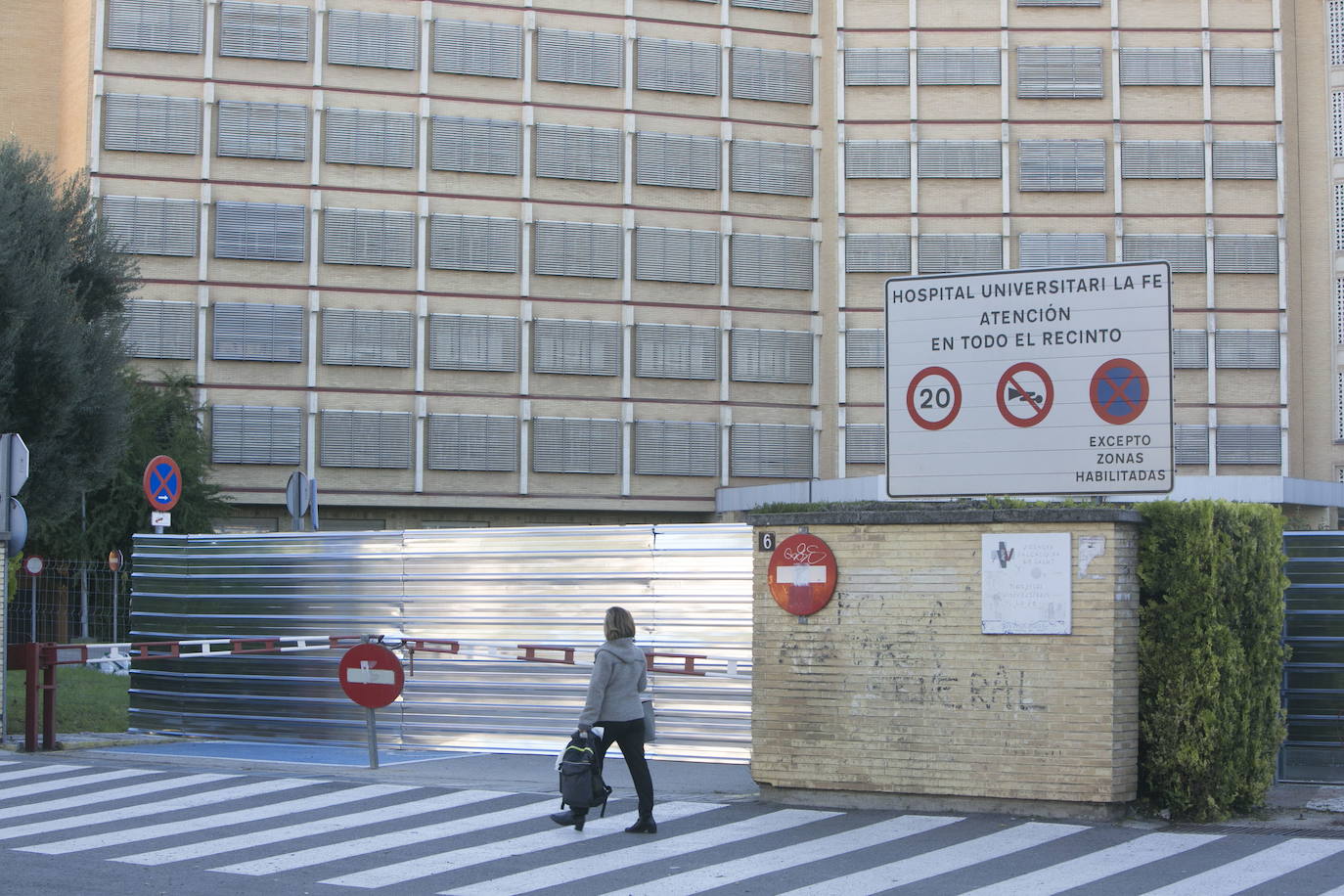 Una persona camina junto a una de las vallas del antiguo Hospital La Fe.