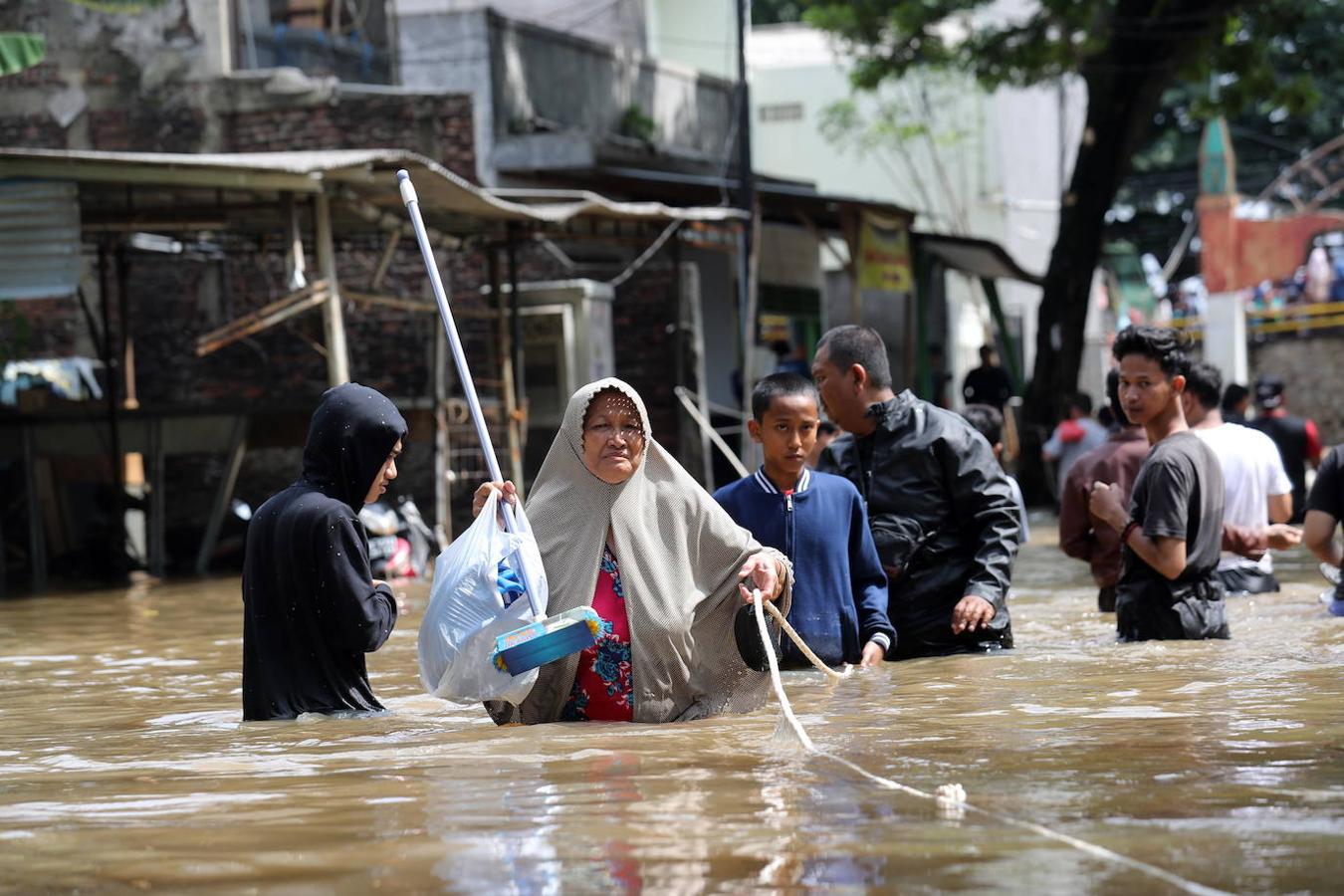 Un grupo de personas atraviesa las calles inundadas de Yakarta, Indonesia.