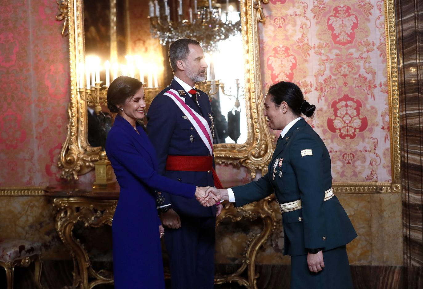 Felipe VI, acompañado por la Reina Letizia, ha presidido este lunes la ceremonia de la Pascua Militar en el Palacio Real. Para la ocasión, Doña Letizia ha elegido un elegante vestido de estilo esmoquin en azul intenso. La Reina ha combinado el diseño, largo hasta los pies, con unos zapatos stilettos en color negro y un peinado recogido acabado en un moño bajo.