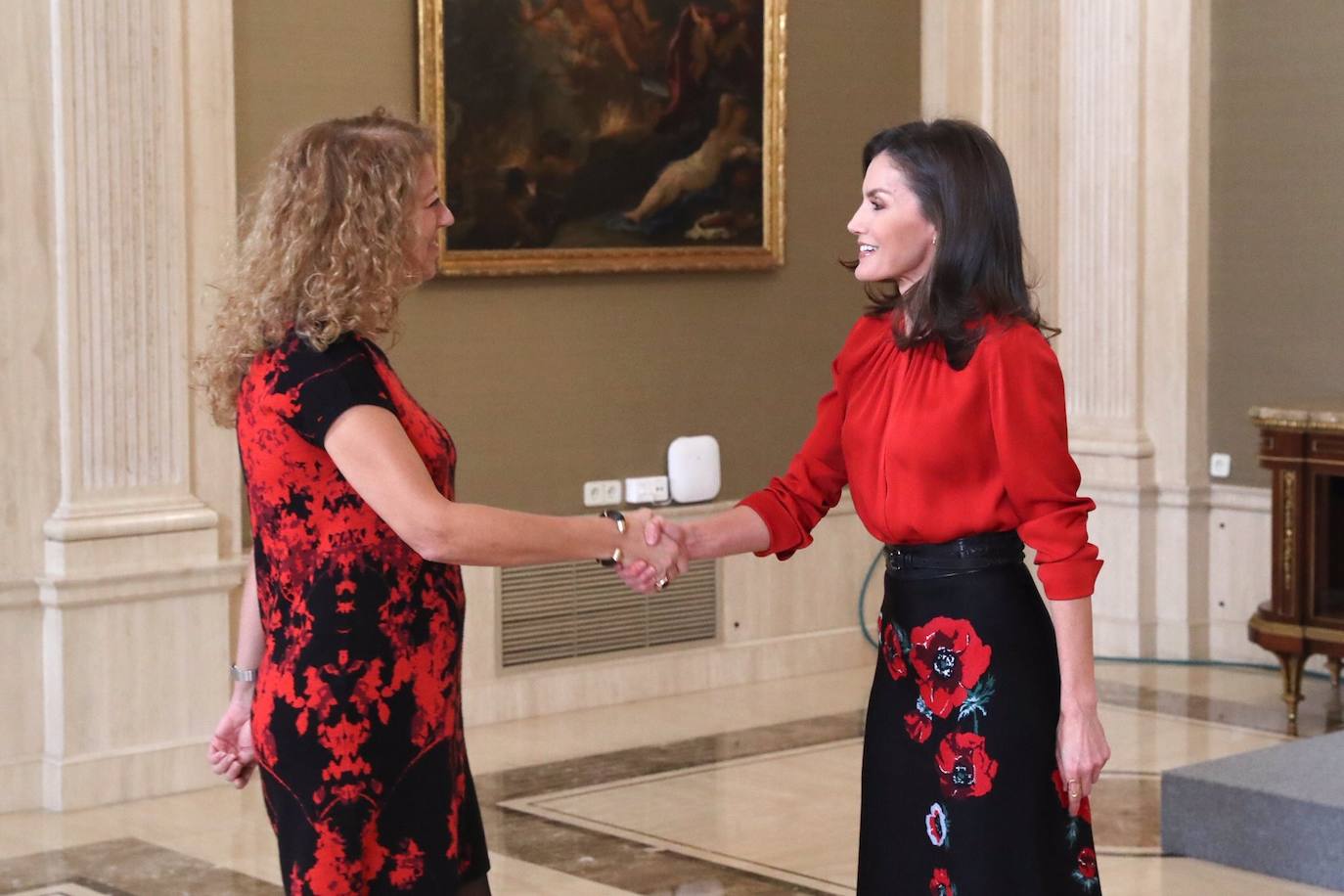 La Reina ha tenido el primer acto de su agenda oficial de esta semana, durante la mañana de este martes, recibiendo audiencias en el Palacio de la Zarzuela. Doña Letizia primero se ha reunido con FEDICINE, la Federación de Distribuidores Cinematográficos y, acto seguido, con la Fundación Mujeres. Para los actos ha optado por el mismo look recuperando antiguas piezas de su armario: una blusa roja de Hugo Boss, falda negra midi de flores estampadas de Carolina Herra combinandola con calzado alto de Magrit.