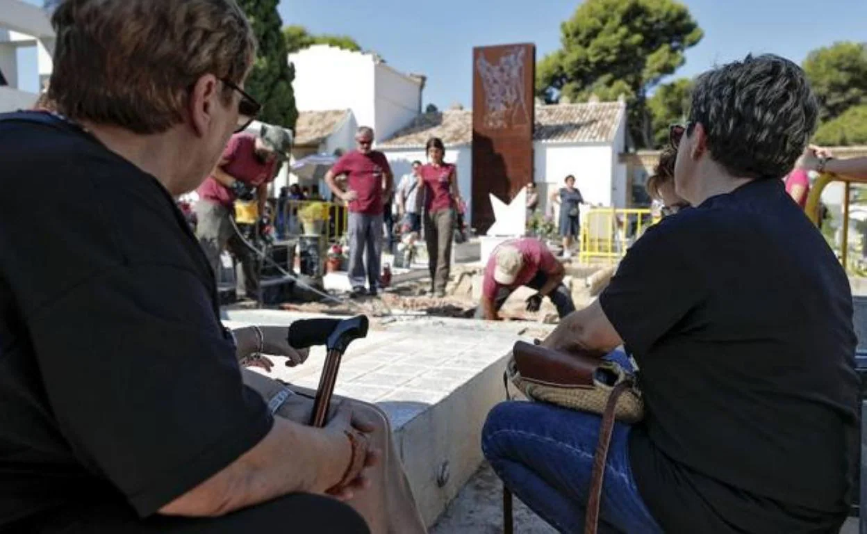 Dos mujeres observan la exhumación de una fosa en el cementerio de Paterna. 