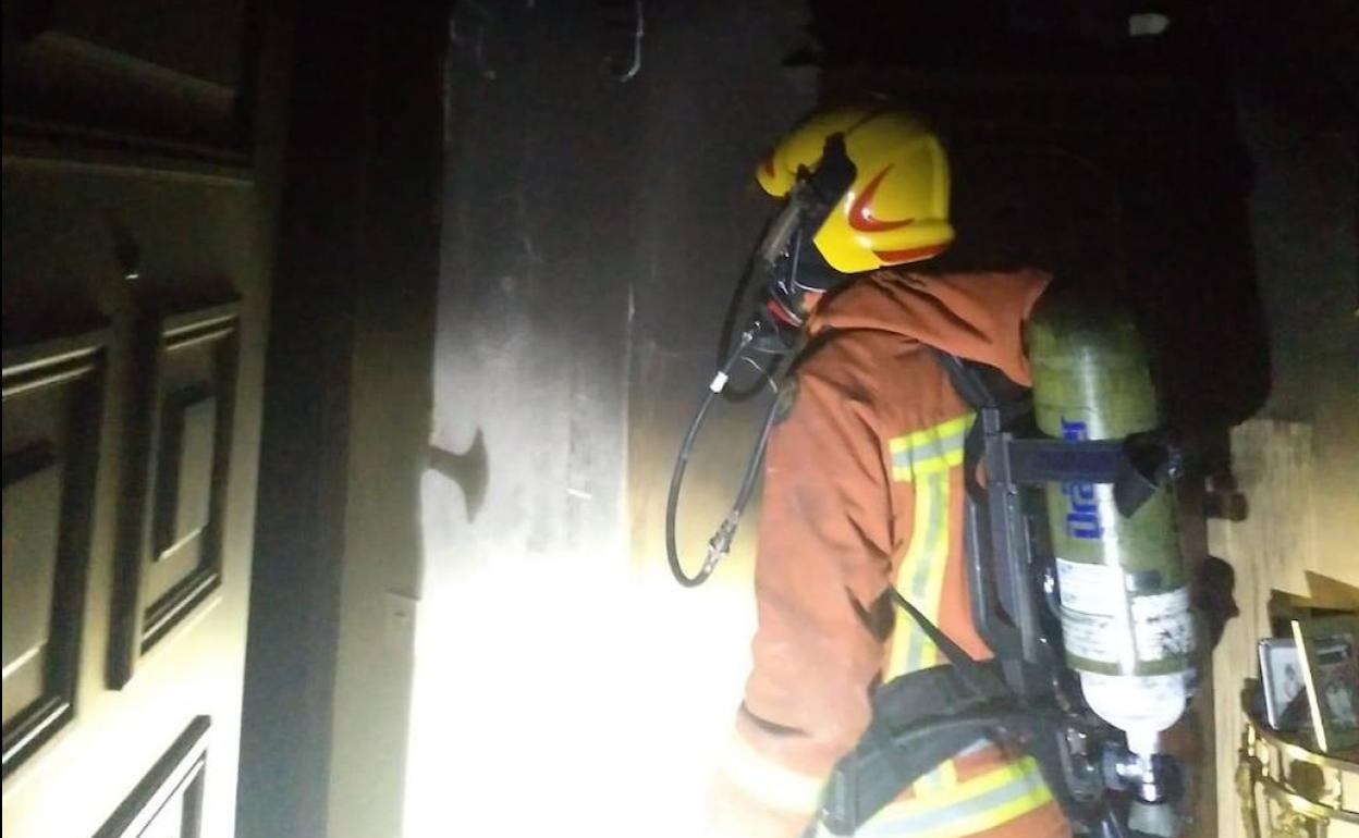 Un bombero en la vivienda donde se produjo el incendio en Beniparrell.