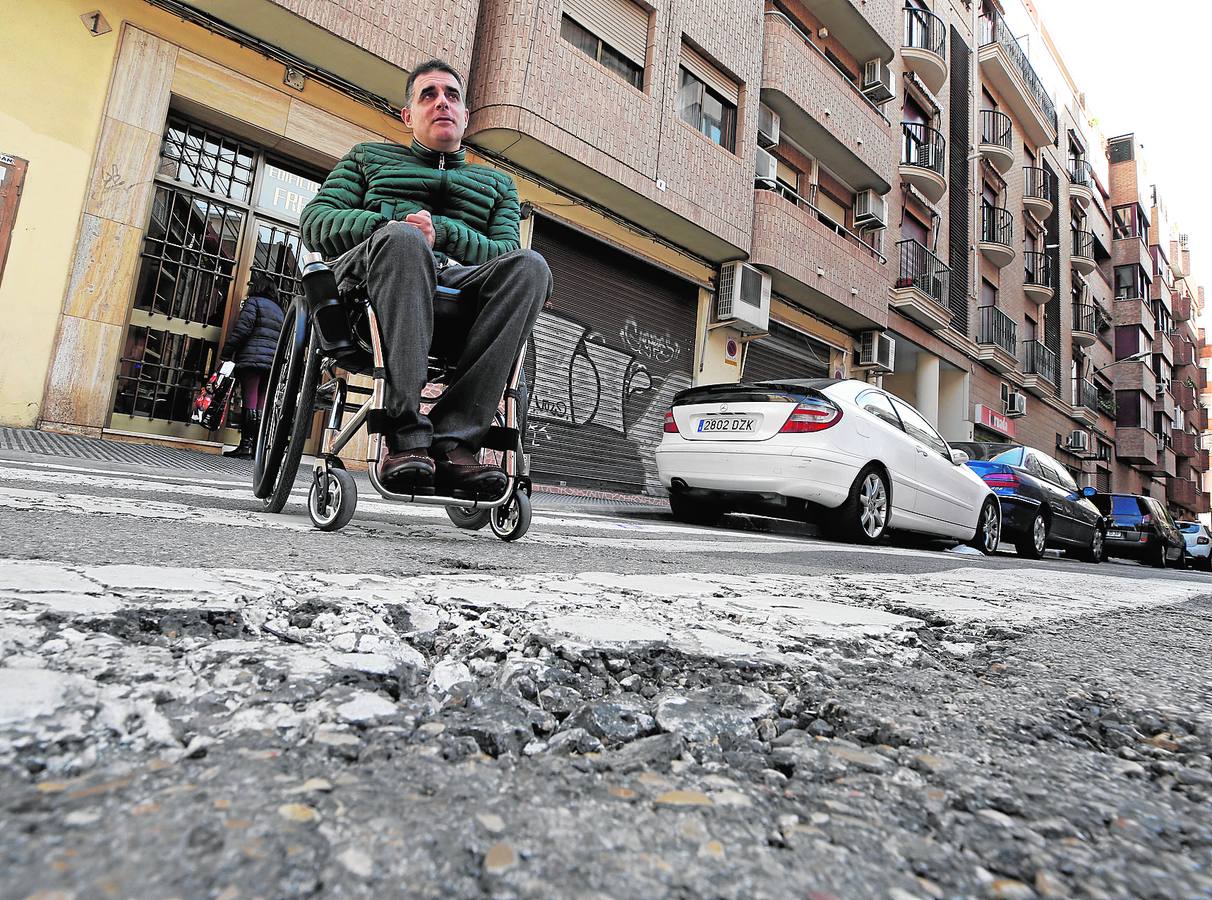 Javier frente a un socavón en un paso de cebra que le impide cruzar en el barrio de Benimaclet.