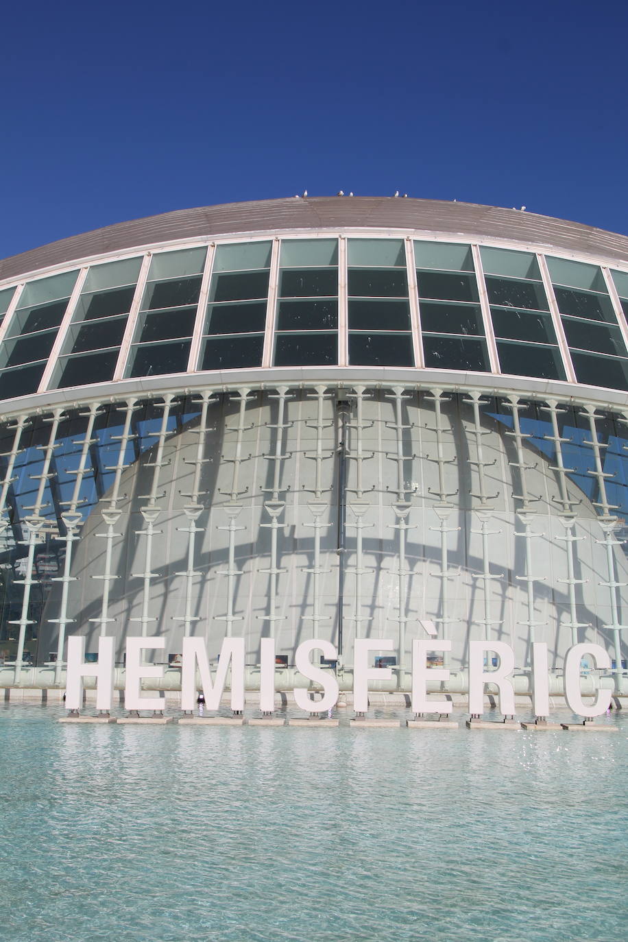 El Ayuntamiento instala las letras con el nombre de la ciudad en la parte trasera del Hemisfèric con el objetivo de sumarse a la campaña de otras ciudades. Las ocho letras mayúsculas guardan el estilo utilizado por CACSA para situar, en la parte frontal de los edificios de la Ciudad de las Artes y de las Ciencias, el nombre de cada uno de ellos. Así, la concejalía de Turismo se sumó en la pasada legislatura a seguir el ejemplo de urbes como Ámsterdam, Vitora o Gijón, entre otros, para tener un punto fotográfico en el cap i casal. La altura de cada elemento es de 1,80 metros y por las noches de iluminará con un sistema led para hacerse más llamativo. El montaje ocupa casi 11 metros de longitud y se podrían desmontar si fuera necesario, según precia el Ayuntamiento. La idea del Consistorio es aprovechar los dos millones de personas que se acercan a este enclave para sumar más presencia de la ciudad en redes sociales.