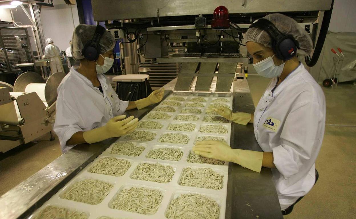 Dos mujeres trabajando en una fábrica.