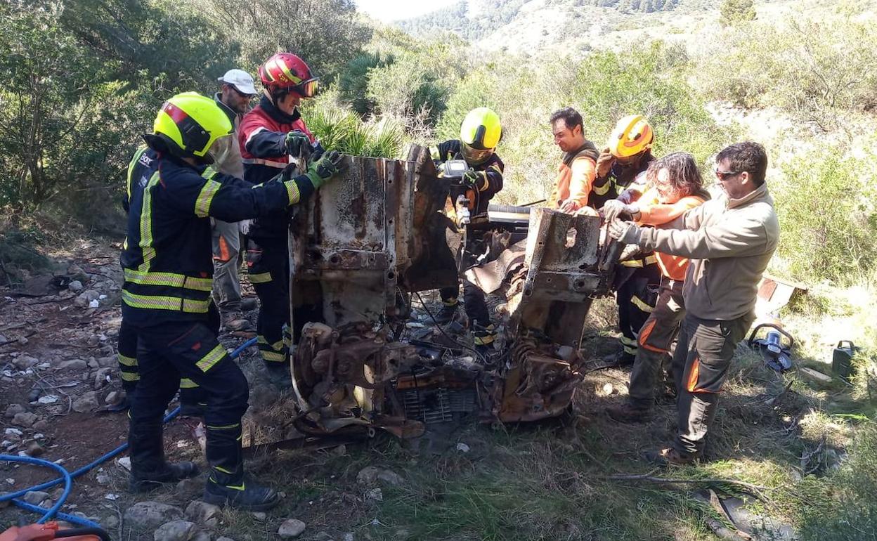 Las labores de retirada de los restos del coche abandonado en el Montgó. 