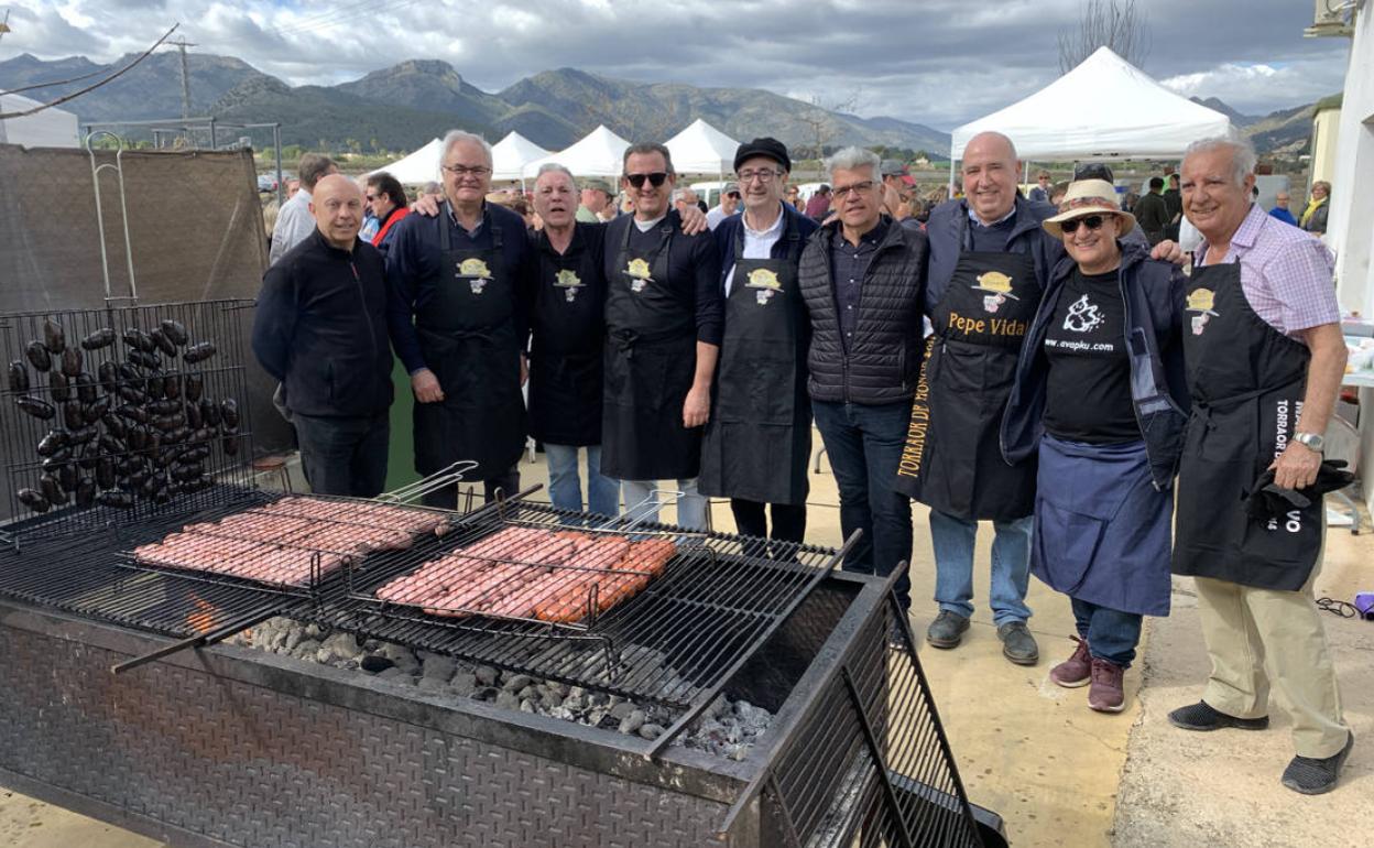 Los torraores preparando el embutido a la brasa durante la feria celebrada en Llíber. 