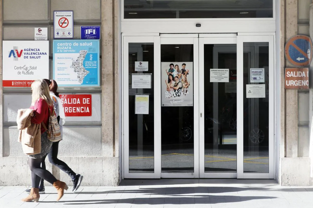 Dos mujeres pasan ante la puerta de un ambulatorio en Valencia. irene marsilla
