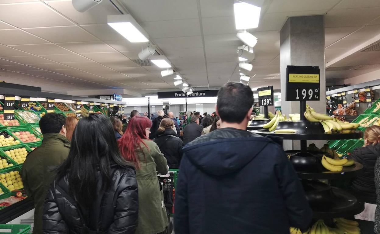 Decenas de personas esperan a pagar su compra este martes en un supermercado Mercadona.