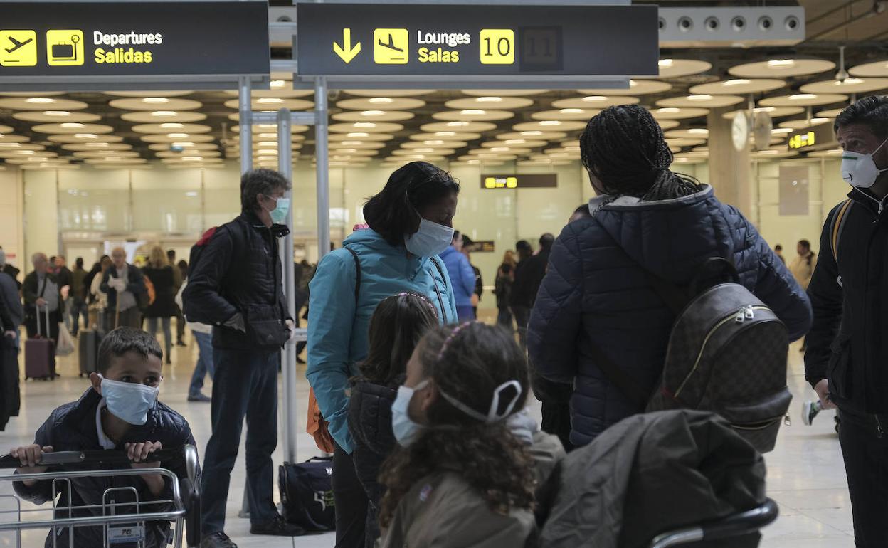 Viajeros con mascarilla se disponen este miércoles a acceder a su vuelo en el Aeropuerto de Barajas.