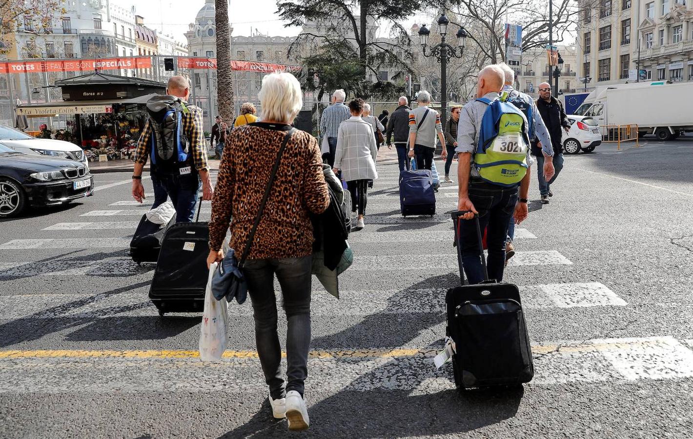 Un grupo de turistas recién llegados a Valencia cruzan por la céntrica plaza del Ayuntamiento. Este sector va a ser uno de los más afectados por la pandemia del coronavirus.