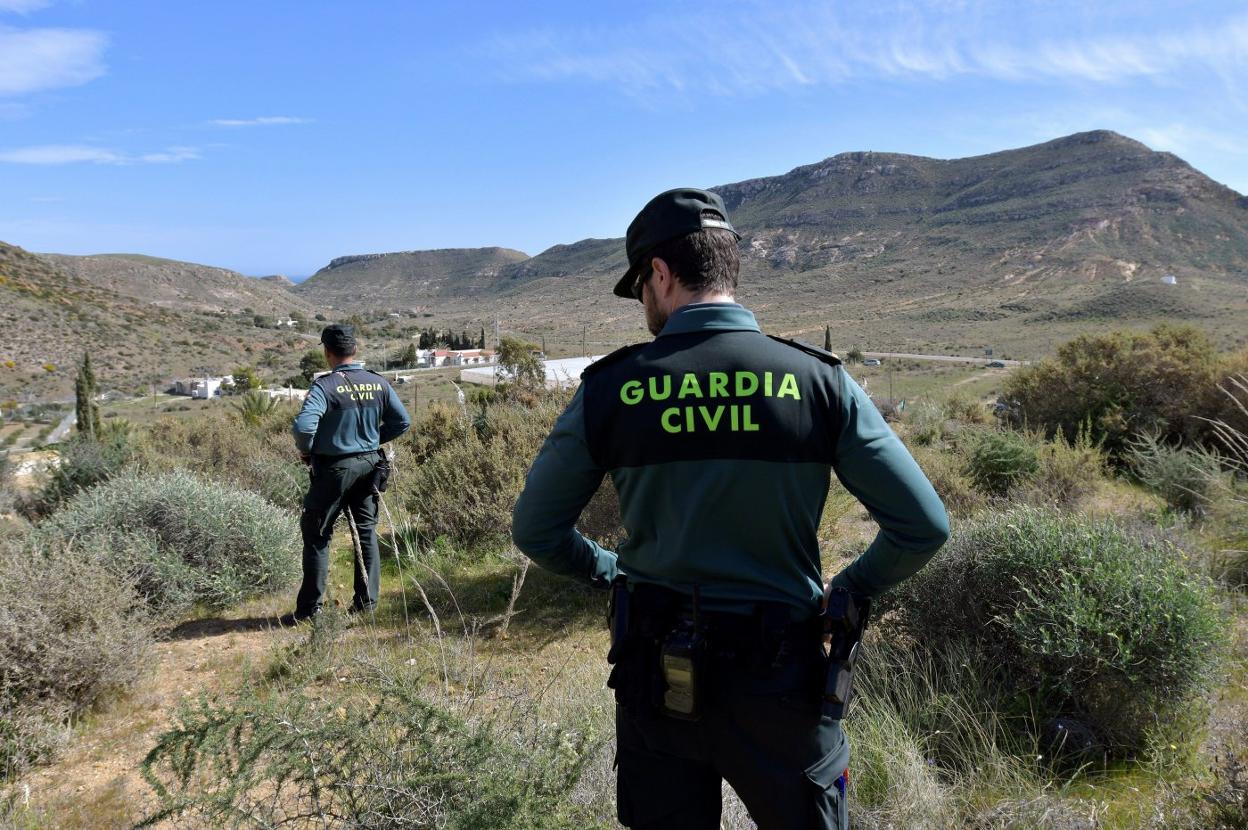 Dos guardias civiles rastrean una zona de monte bajo. efe