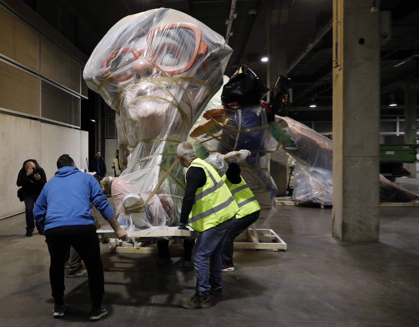 Las instalaciones de Feria Valencia han empezado a acoger, a última hora de este viernes, las piezas de distintas fallas de València que no habían sido aún plantadas en las calles y que permanecerán ahora resguardadas hasta el próximo mes de julio. Piezas de gran tamaño y de todos los colores y formas posibles han ido entrando paulatinamente a bordo de varios camiones en una de las grandes naves de Feria Valencia habilitadas expresamente para esta medida de urgencia, adoptada esta semana tras la decisión del aplazamiento de las Fallas ante la pandemia del coronavirus. Está previsto que distintas comisiones falleras lleven allí sus piezas más grandes hasta julio, cuando volverán a tomar las calles para la Plantà definitiva de los monumentos, que arderán el 19 de julio.