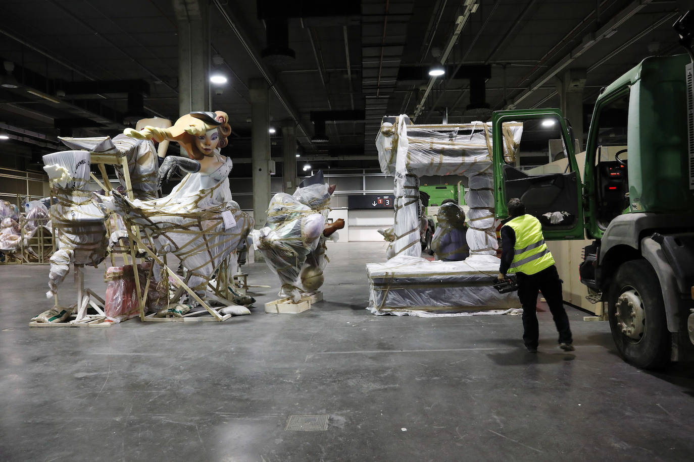 Las instalaciones de Feria Valencia han empezado a acoger, a última hora de este viernes, las piezas de distintas fallas de València que no habían sido aún plantadas en las calles y que permanecerán ahora resguardadas hasta el próximo mes de julio. Piezas de gran tamaño y de todos los colores y formas posibles han ido entrando paulatinamente a bordo de varios camiones en una de las grandes naves de Feria Valencia habilitadas expresamente para esta medida de urgencia, adoptada esta semana tras la decisión del aplazamiento de las Fallas ante la pandemia del coronavirus. Está previsto que distintas comisiones falleras lleven allí sus piezas más grandes hasta julio, cuando volverán a tomar las calles para la Plantà definitiva de los monumentos, que arderán el 19 de julio.