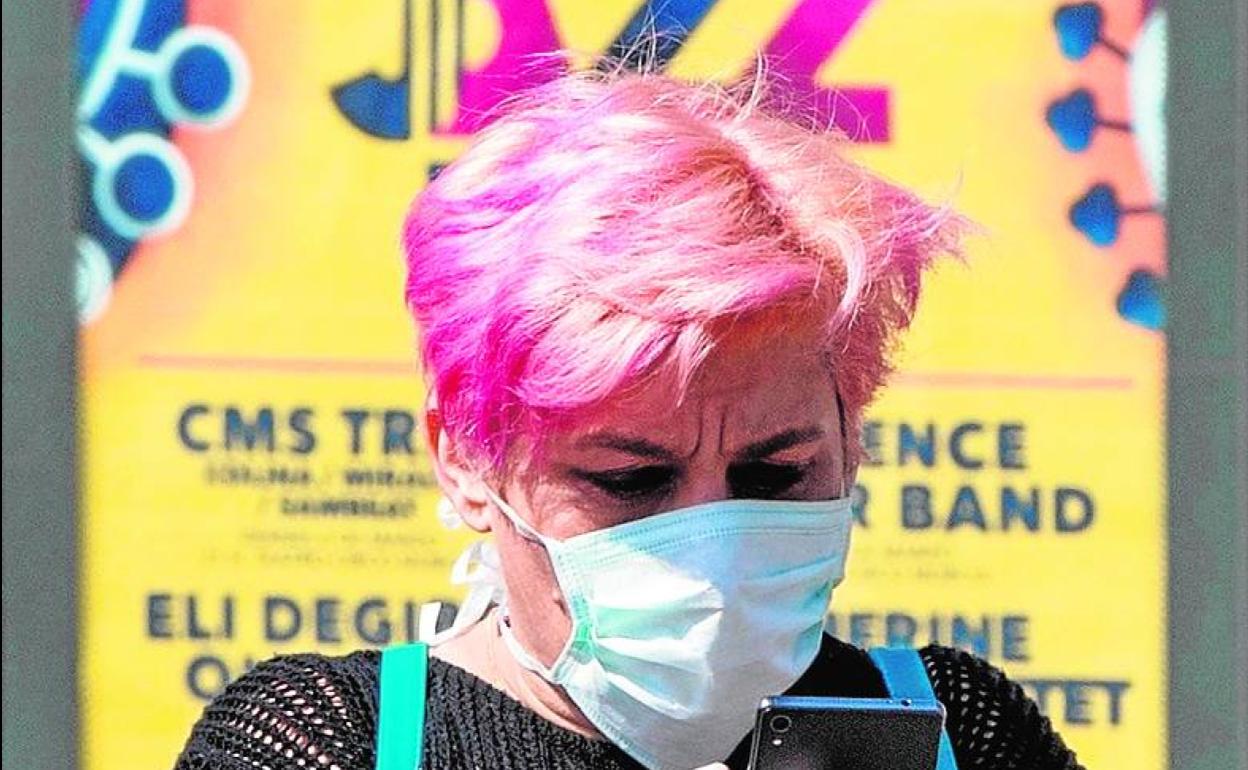Una mujer, con guantes y mascarilla para protegerse del coronavirus.