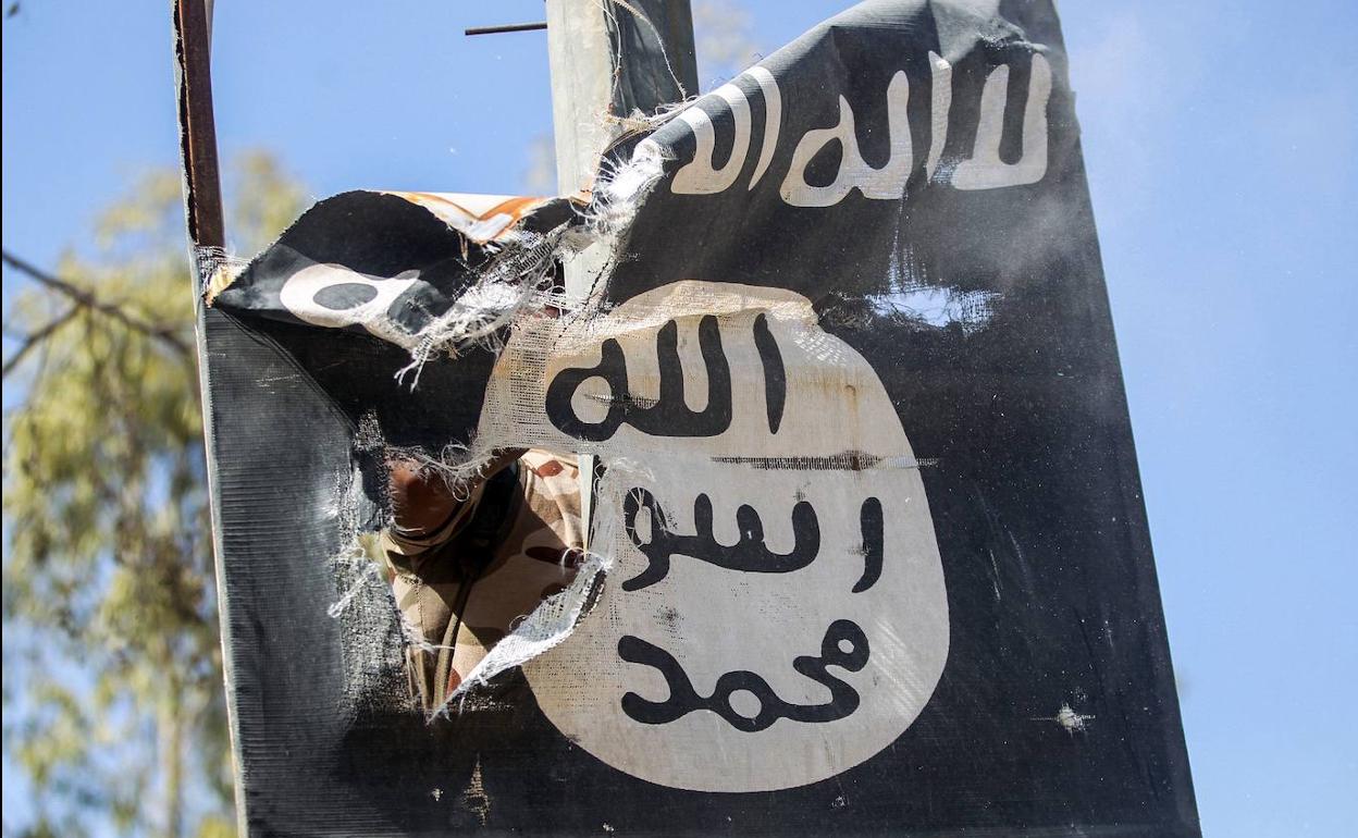 Un miliciano retira una bandera del Dáesh cerca de Mosul.