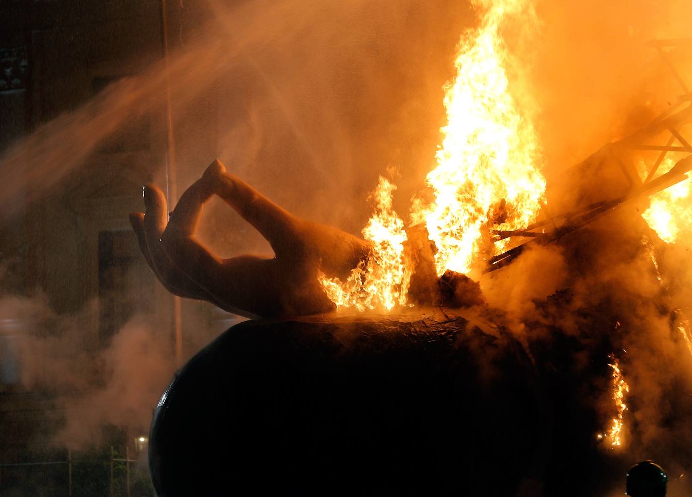 Los bomberos hacen arder la parte ya plantada de la falla del Ayuntamiento. La cabeza de la chica se guardará para la celebración de julio.