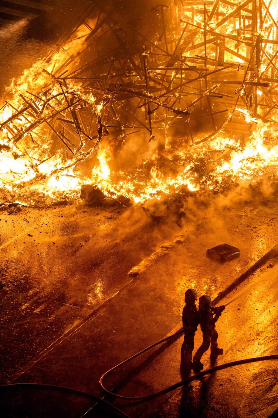 Los bomberos hacen arder la parte ya plantada de la falla del Ayuntamiento. La cabeza de la chica se guardará para la celebración de julio.