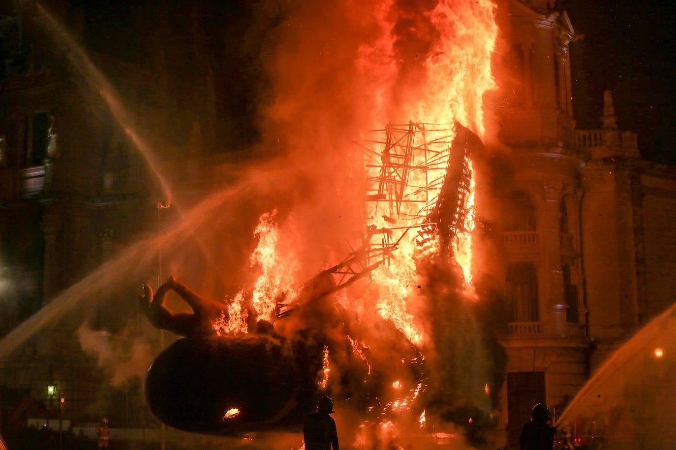 Los bomberos hacen arder la parte ya plantada de la falla del Ayuntamiento. La cabeza de la chica se guardará para la celebración de julio.