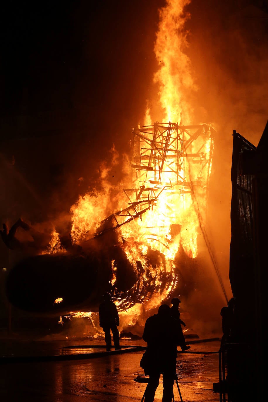 Los bomberos hacen arder la parte ya plantada de la falla del Ayuntamiento. La cabeza de la chica se guardará para la celebración de julio.