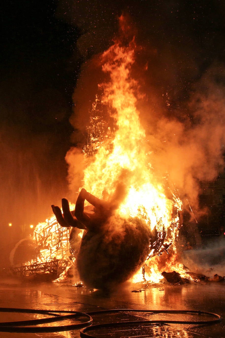 Los bomberos hacen arder la parte ya plantada de la falla del Ayuntamiento. La cabeza de la chica se guardará para la celebración de julio.