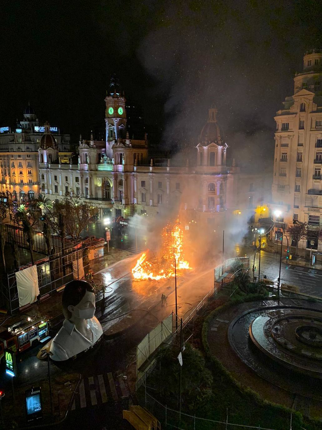 Los bomberos hacen arder la parte ya plantada de la falla del Ayuntamiento. La cabeza de la chica se guardará para la celebración de julio.