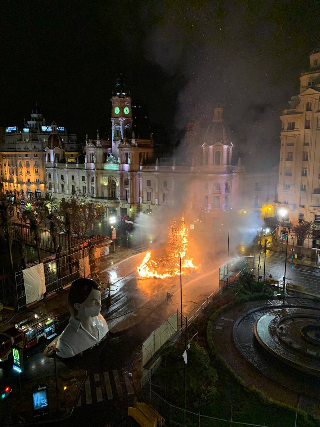 Los bomberos hacen arder la parte ya plantada de la falla del Ayuntamiento. La cabeza de la chica se guardará para la celebración de julio.