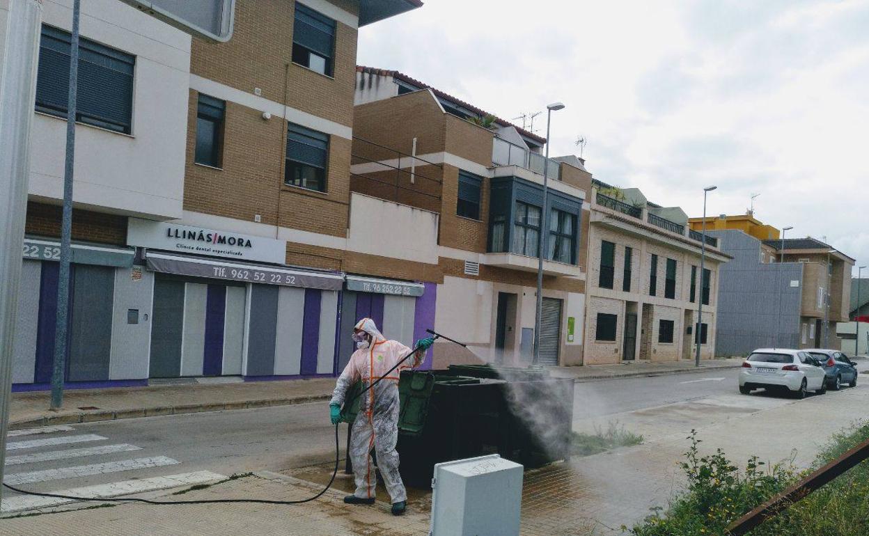 Un agricultor pulveriza una calle en Chiva para desinfectar. 