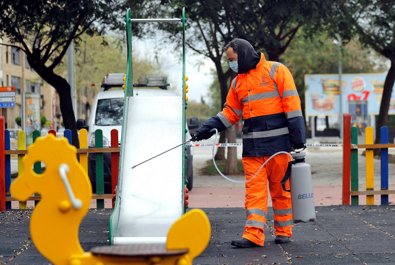 Un trabajador del servicio municipal de vía pública de Alboraia desinfectan un parque infantil.