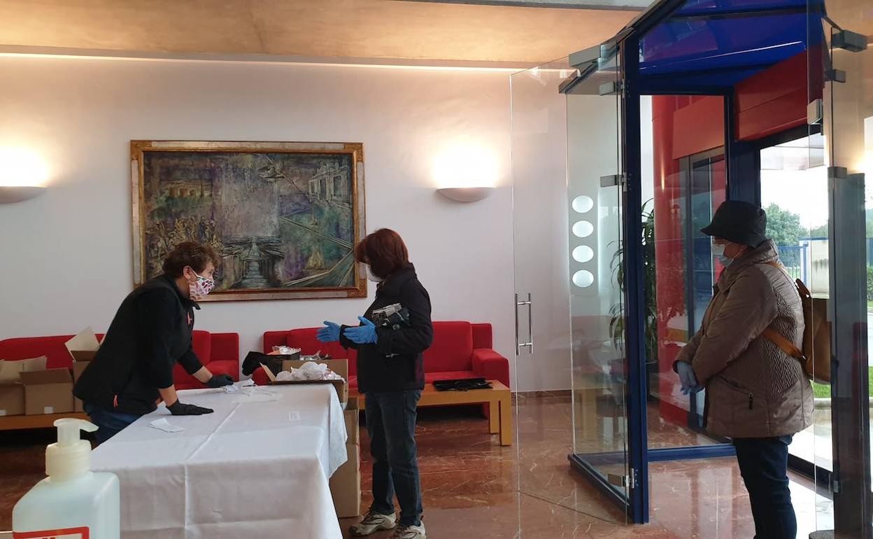 Dos voluntarios recogen en la sede de Rolser algunas de las unidades para su confección.