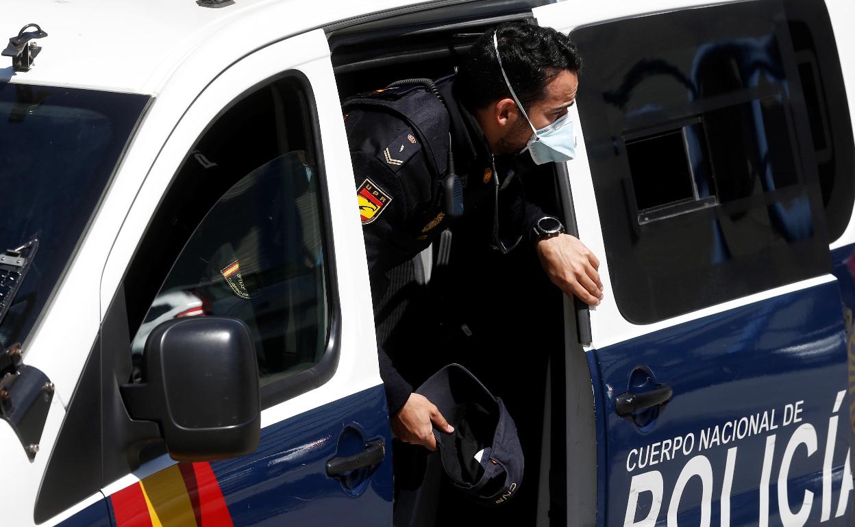 Un policía nacional desciende de un furgón. 