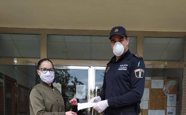 Sabrina Marco entrega las mascarillas a un Policía Local. 